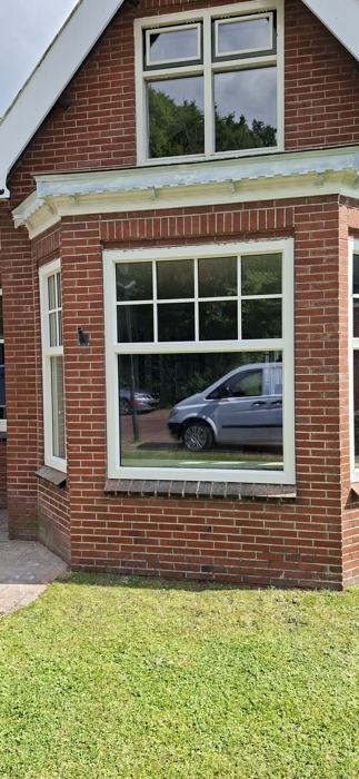 Detail van een witte erker met bovenlicht