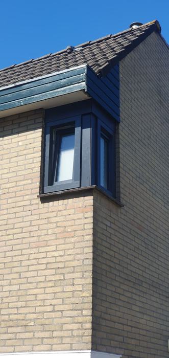 Antraciet hoekkozijnen in een gele bakstenen gevel